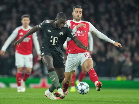 Hráč Bayernu Dayot Upamecano (vpredu) uniká s loptou pred Mikelom Merinom z Arsenalu počas zápasu 5. kola ligovej fázy Ligy majstrov FC Arsenal - Bayern Mníchov.
