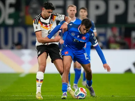 Aleksandar Pavlovic a David Strelec počas zápasu Nemecko - Slovensko v kvalifikácii MS vo futbale 2026. 