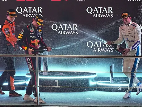 Oscar Piastri, Max Verstappen a Carlos Sainz striekajú šampanské po Veľkej cene Kataru F1.