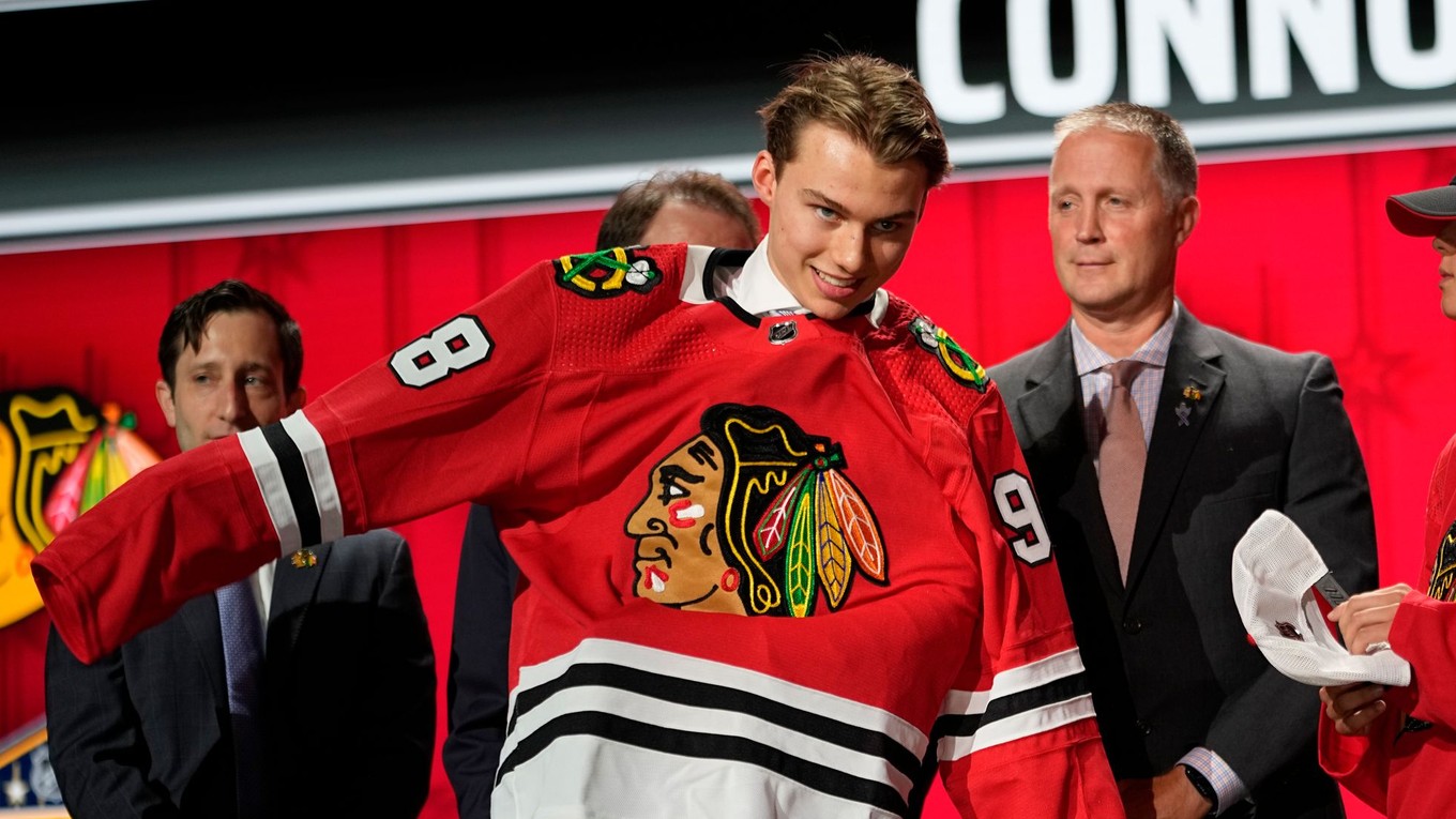 Draftová jednotka Connor Bedard si oblieka dres Chicaga Blackhawks v drafte NHL 2023.