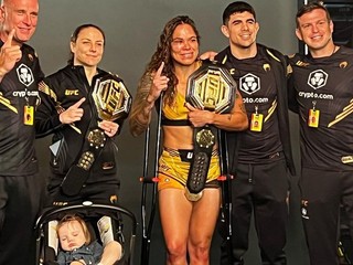 Amanda Nunes oslavuje výhru spolu so svojou manželkou Ninou (vľavo), dcérou a trénermi.