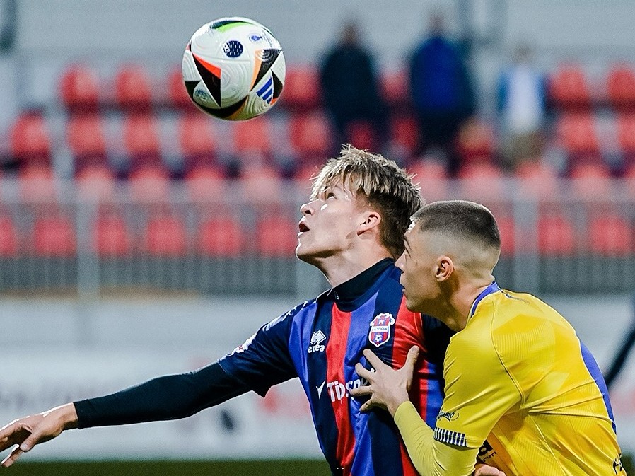 V drese FC ViOn v piatok debutoval 17–ročný Matej Majerčík (vľavo), odchovanec PFA,
ktorého bráni Matúš Bega z Humenného.