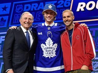Gavin McKenna počas draftu NHL s komisárom Garym Bettmanom a spevákom Justinom Bieberom.