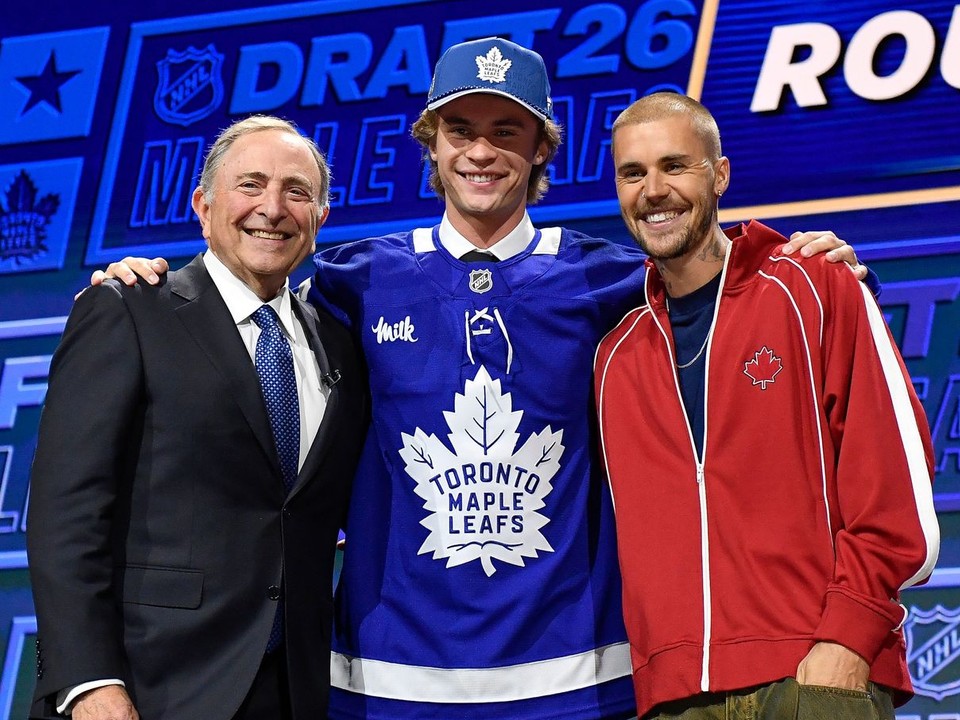 Gavin McKenna počas draftu NHL s komisárom Garym Bettmanom a spevákom Justinom Bieberom.