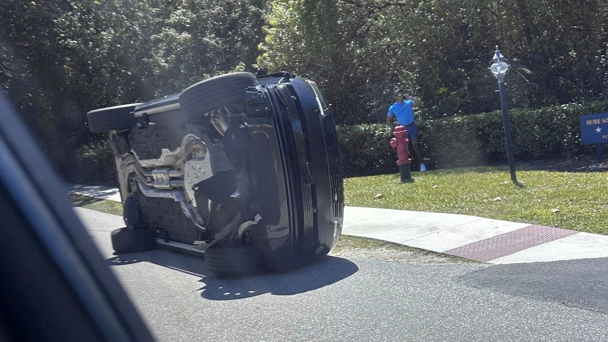 Golfista Tiger Woods stojí pri svojom prevrátenom vozidle.