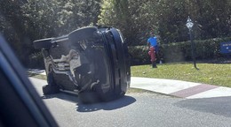 Golfista Tiger Woods stojí pri svojom prevrátenom vozidle.