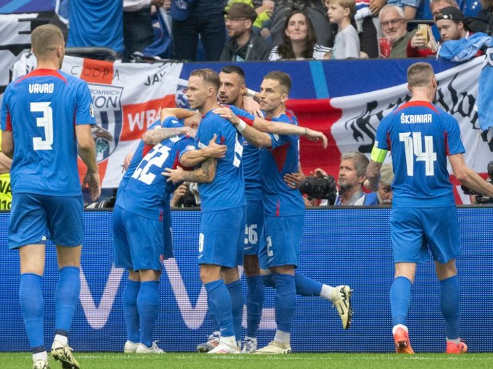 Slovenskí futbalisti oslavujú gól.
