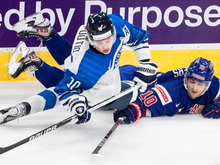 Americký hokejista Matty Beniers (vpravo) a Fín Kasper Puutio bojujú o puk počas prípravného zápasu USA - Fínsko.