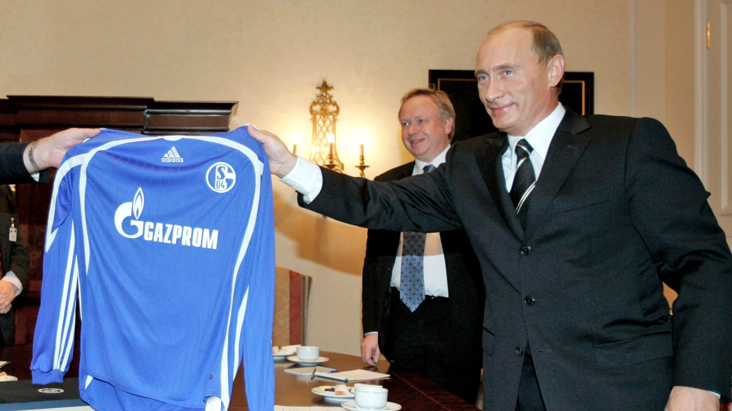 Ruský prezident Vladimir Putin drží dres nemeckého futbalového klubu z Gelsenkirchenu s logom nového sponzora Gazprom v roku 2006.