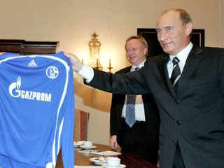 Ruský prezident Vladimir Putin drží dres nemeckého futbalového klubu z Gelsenkirchenu s logom nového sponzora Gazprom v roku 2006.