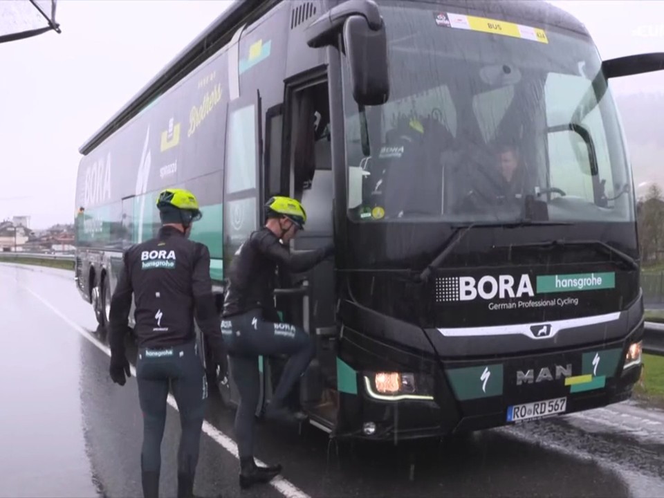 Jazdci tímu Bora-Hansgrohe nastupujú do tímového autobusu, aby sa presunuli na nový štart 16. etapy.