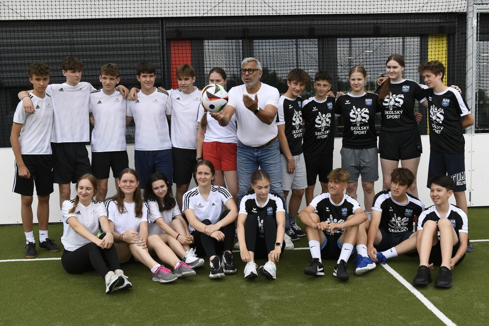 Futbalový vyslanec UEFA EURO 2024 Jimmy Hartwig (uprostred) pózuje so žiakmi Nemeckej školy Bratislava.