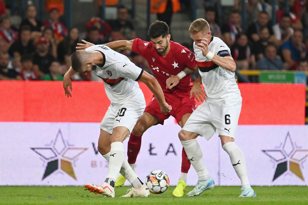 Na snímke zľava hráč Trnavy Adrian Zelkovič, hráč Krakova Marc Carbo a kapitán Trnavy Roman Procházka počas odvetného zápasu 3. predkola Európskej konferenčnej ligy (EKL) medzi Wisla Krakov - FC Spartak Trnava vo štvrtok 15. augusta 2024 v Krakove. 