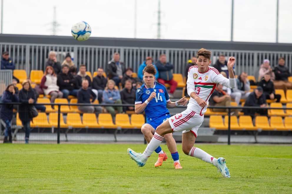 V kádri reprezentačnej osemnástky nechýba ani Simon Nináč, na fotografii v modrom strieľajúc cez Zsolta Cserkutiho v prípravnom zápase Slovensko U18 – Maďarsko U18 v Dunajskej Strede (3.10.2024)