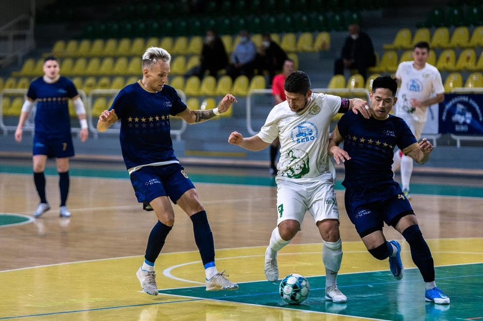 Domáci kapitán Viliam Rakica v súboji s hráčmi CopyLeaders Prievidza Martinom Antolom (vľavo) a Longjie Xia (vpravo) v zápase 9.kola 1.SLF v ŠH Levice 11. novembra 2021.