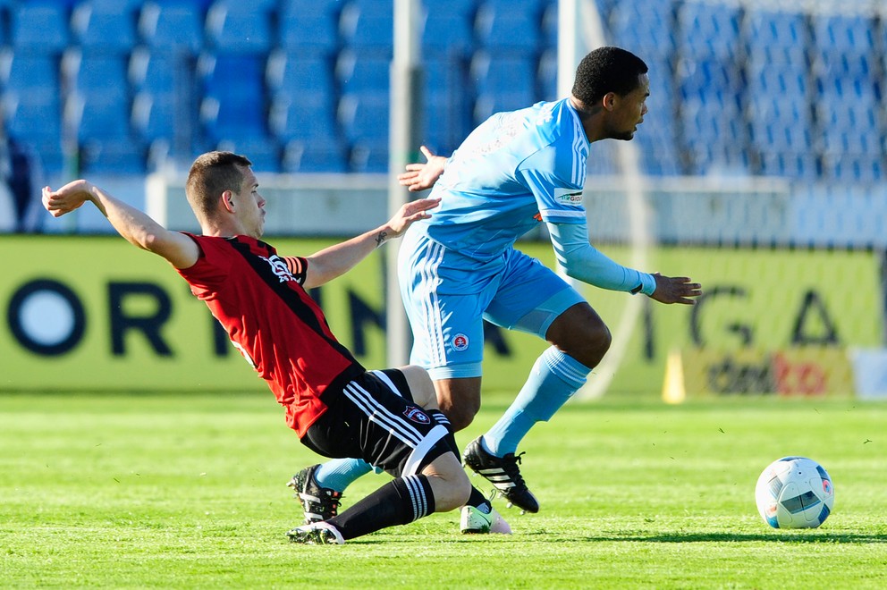 Martin Mikovič (vľavo) sa snaží sklzom vypichnúť loptu hráčovi Slovana Granwaldovi Scottovi.