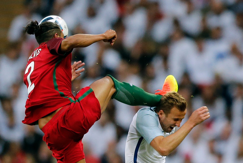Portugalský stopér Bruno Alves (vľavo) za tento nevyberaný zákrok videl červenú kartu.