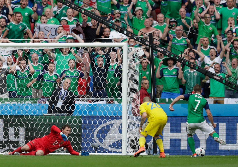 Niall McGinn (vpravo) strieľa druhý gól Severného Írska v zápase.