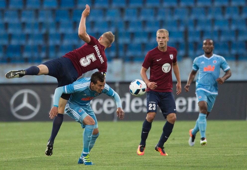 Na snímke druhý zľava hráč Slovana František Kubík a hráči FK Jelgavy vľavo Gints Freimanis a Glebs Kluškins (druhý sprava).