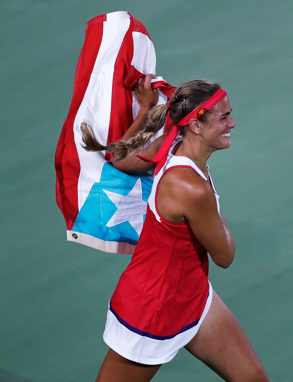 Puigová beží s portorickou vlajkou.