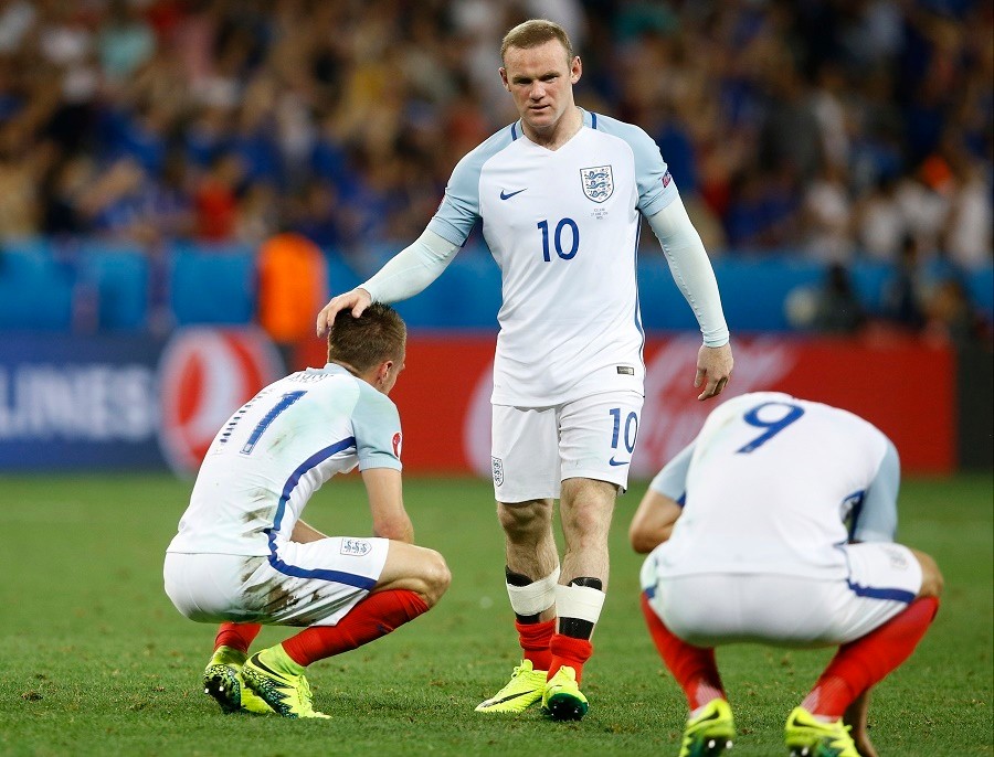 Wayne Rooney (v strede) utešuje spoluhráčov po prehre s Islandom.