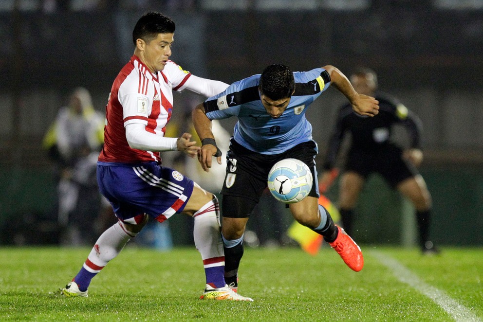 Jorge Moreira z Paraguaja (vľavo) v súboji o loptu s Luisom Suarezom z Uruguaja.