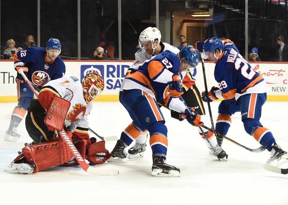 Brankár Calgary Brian Elliott čelí šanci hráčov New Yorku Islanders.