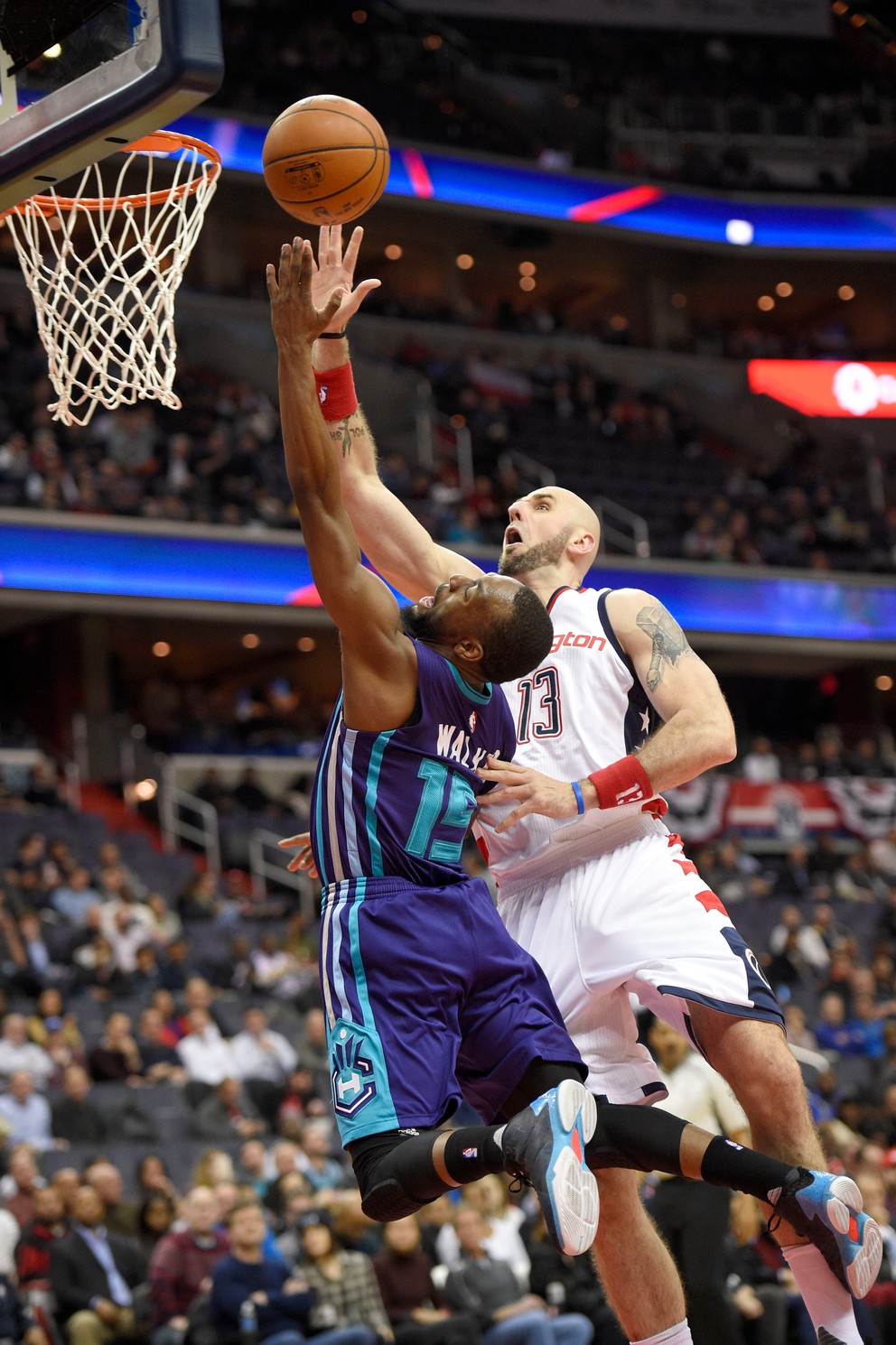 O loptu vo výskoku bojujú Kemba Walker zo Charlotte (vľavo) a hráč Washingtonu Marcin Gortat.