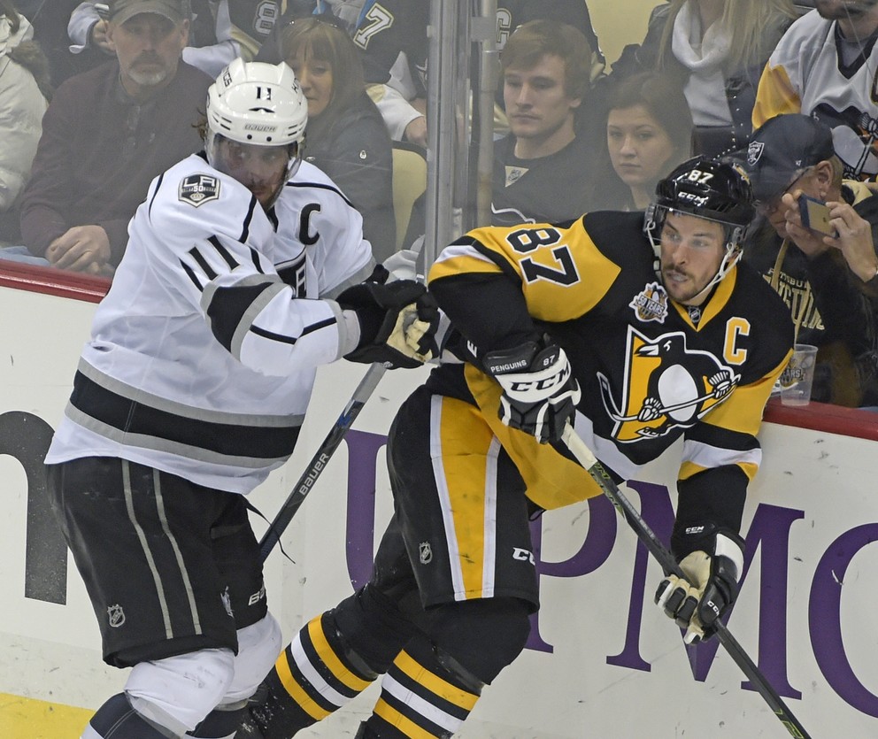 Súboj kapitánov - Anže Kopitar z Los Angeles (vľavo) atakuje Sidneyho Crosbyho.