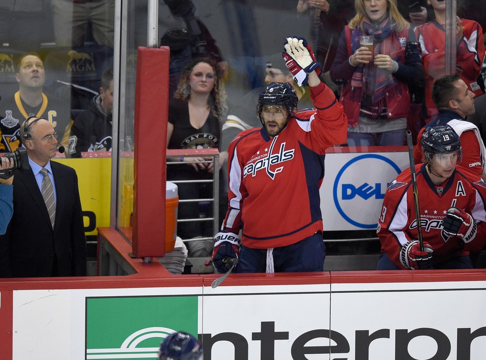 Alexander Ovečkin zdraví aplaudujúci dav po tom, ako zaznamenal svoj tisíci bod v NHL.