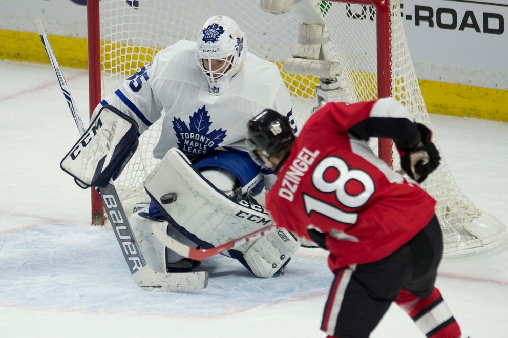 Brankár Toronta Curtis McElhinney zasahuje pri šanci Ryana Dzingela.