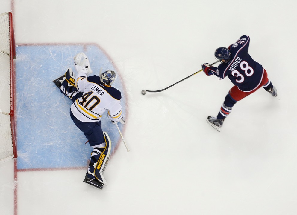 Brankár Buffala Robin Lehner zasahuje pri šanci Boonea Jennera.