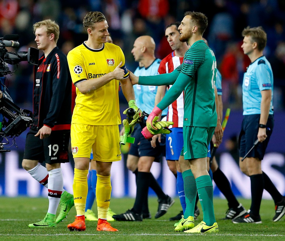 Brankár Leverkusenu Bernd Leno (vľavo) blahoželá Janovi Oblakovi z Atlética Madrid.