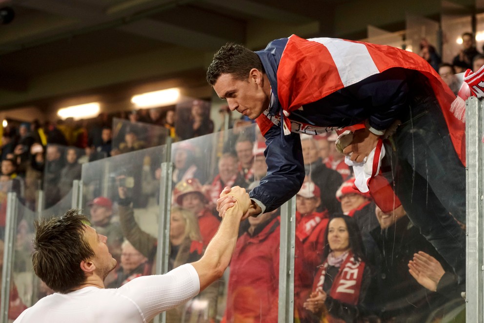 Dánsky futbalista William Kvist si podáva ruku s jedným z fanúšikov.