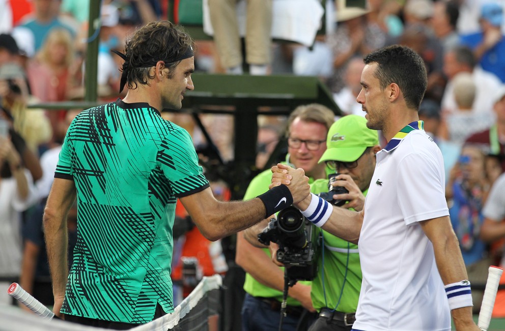 Roger Federer (vľavo) prijíma gratuláciu od Roberta Bautistu Aguta.