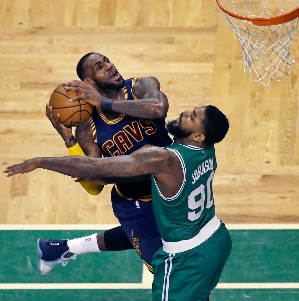 LeBron James (vľavo) z Clevelandu sa prediera do zakončenia cez Amira Johnsona.