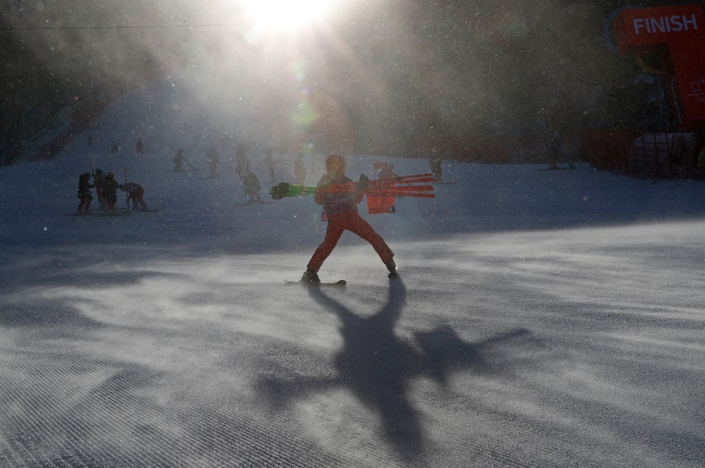 Traťový pracovník odnáša bránky zo svahu obrovského slalomu žien, ktorý z dôvodu silného vetra preložili.