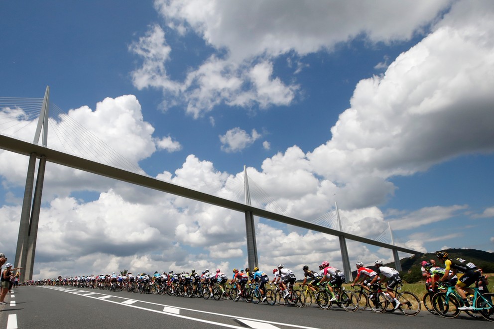 Cyklisti počas 15. etapy Tour de France 2018 prechádzajú popod slávny viadukt v Millau.