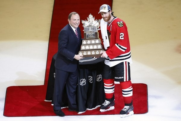 Duncan Keith (vpravo) preberá od komisára NHL Garyho Bettmana Conn Smythe Trophy pre najužitočnejšieho hráča play-off.