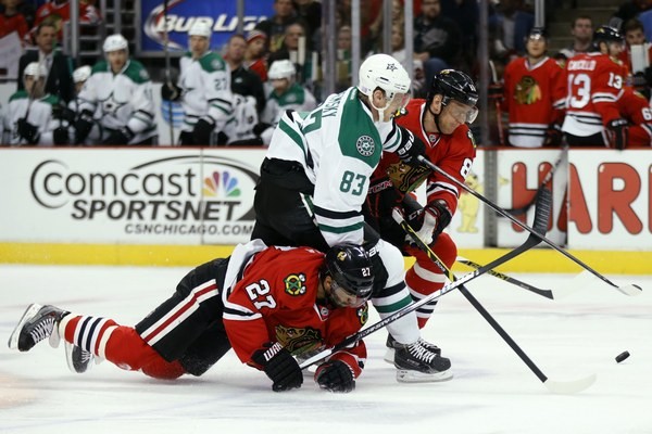 Aleš Hemský s číslom 83 z Dallasu a hráči Chicaga Johnny Oduya (27) a Marián Hossa (81).