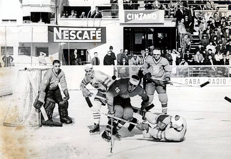 Momentka zo zápasu Československo - Švédsko z MS 1961. Hralo sa krátko popoludní na otvorenom klzisku v Lausanne, hráči mali preto pod očami namaľované čierne pásiky.