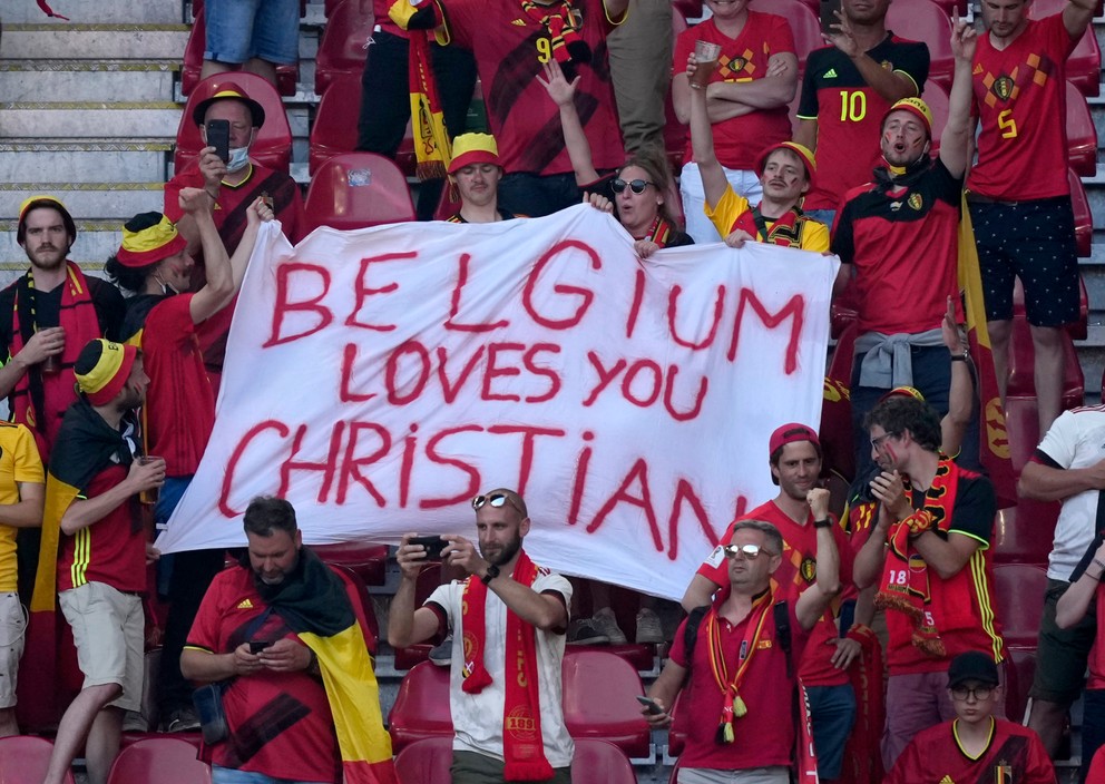 Belgickí fanúšikovia podporujú Christiana Eriksena po kolapse na EURO 2020.