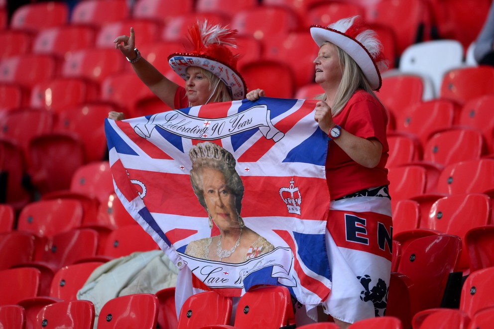 Anglickí fanúšikovia s vlajkou s britskou kráľovnou na EURO 2020.