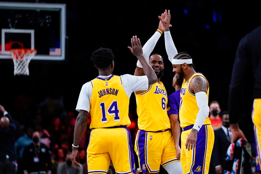 Hráč Los Angeles Lakers LeBron James (6) oslavuje so spoluhráčmi Carmelom Anthonym (vpravo) a Stanleyom Johnsonom (vľavo).