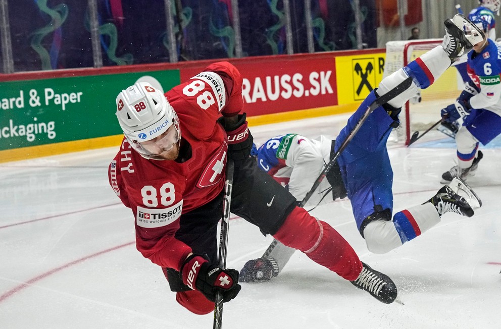 Švajčiarsky útočník Christoph Bertschy v tvrdom súboji s Tomášom Tatarom. 