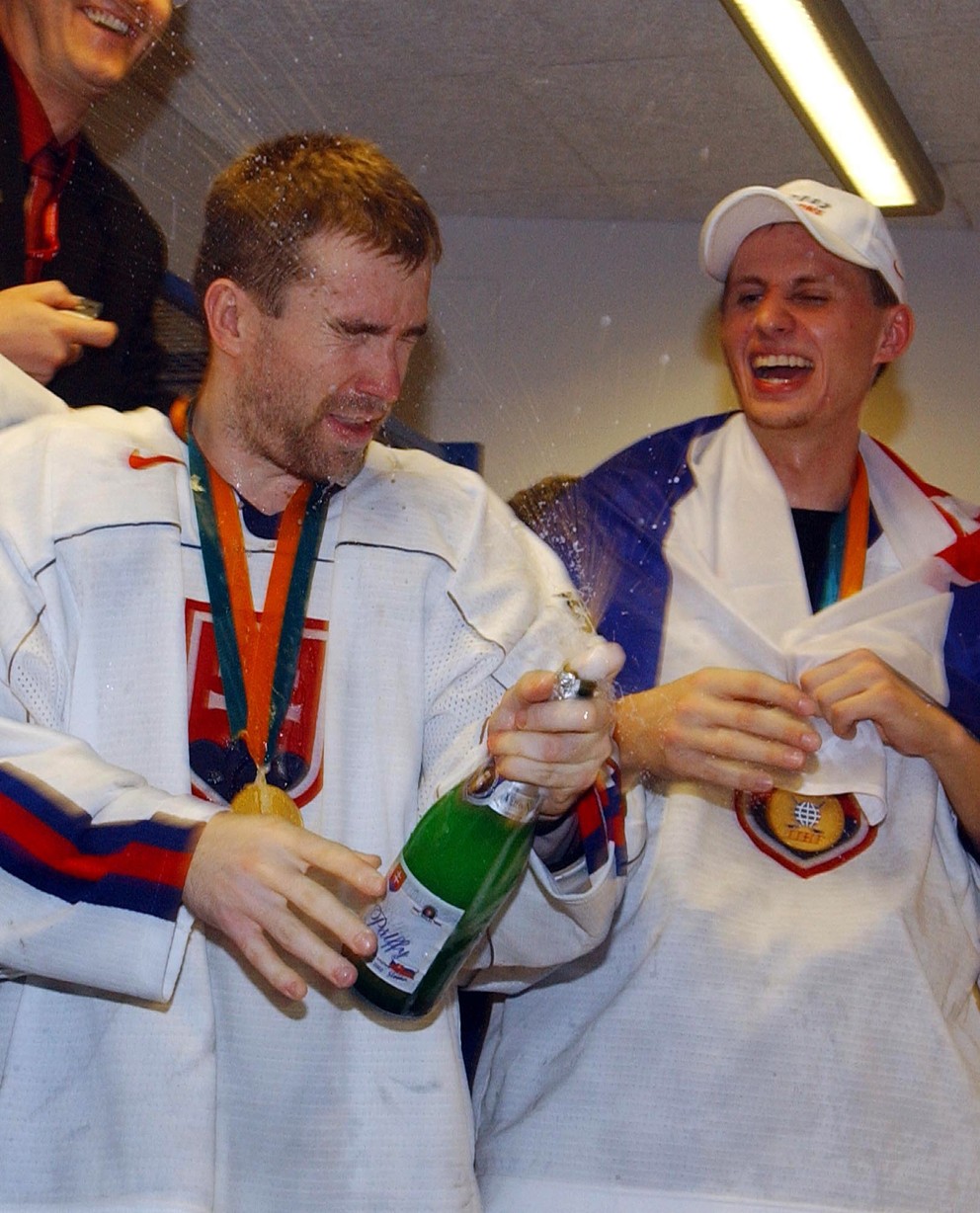 Žigmund Pálffy otvára v šatni fľašu šampusu po triumfe Slovenska na MS v hokeji 2002. Vedľa neho stojí Rastislav Staňa.