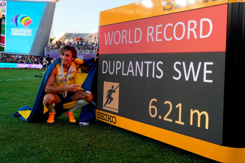 Tradičného pózovanie svetového rekordéra a majstra sveta Armanda Duplantisa  pred elektronickou tabuľou. 