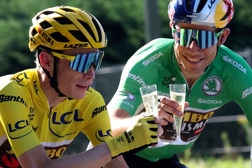 Jonas Vingegaard v žltom drese a Wout van Aert v zelenom si pripíjajú na začiatku záverečnej etapy Tour de France 2022.