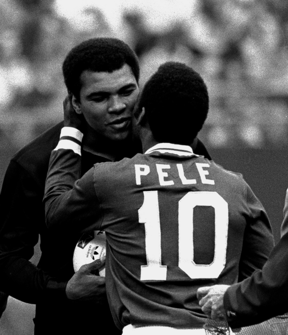 Futbalista Pelé sa objíma s boxerom Muhammadom Alim počas ceremónie na počesť brazílskej futbalovej hviezdy New York Cosmos na Giants Stadium, East Rutherford, NJ, 1. októbra 1977.