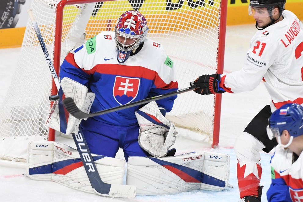 Brankár Slovenska Samuel Hlavaj (vľavo) a center Kanady Scott Laughton (vpravo) v zápase Slovensko - Kanada na MS v hokeji 2023.
